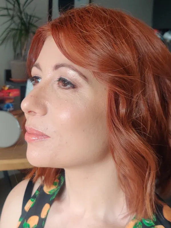 Close-up beauty portrait featuring neutral shimmer eyeshadow, crisp eyeliner, and a pink lip