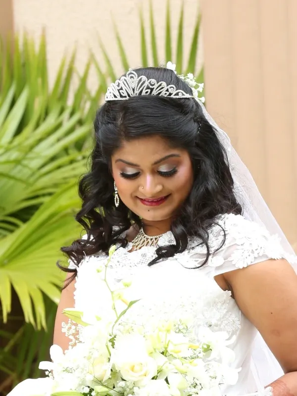 Bride in white gown with tiara, soft shimmer eye and bridal bouquet