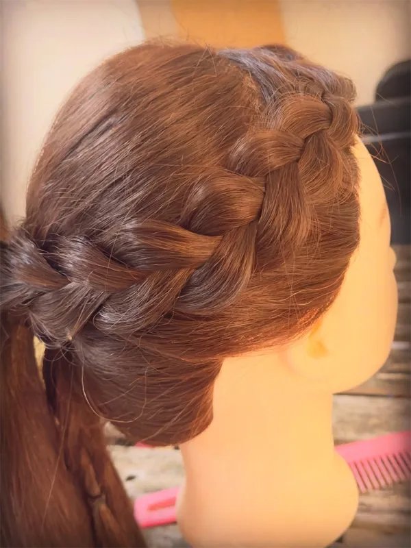 Side view of a Dutch side braid sweeping across the crown on a mannequin head