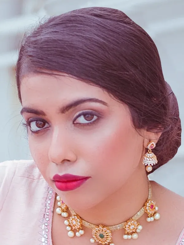 Bridal-style kohl liner, berry lip and gold jewellery on sleek updo